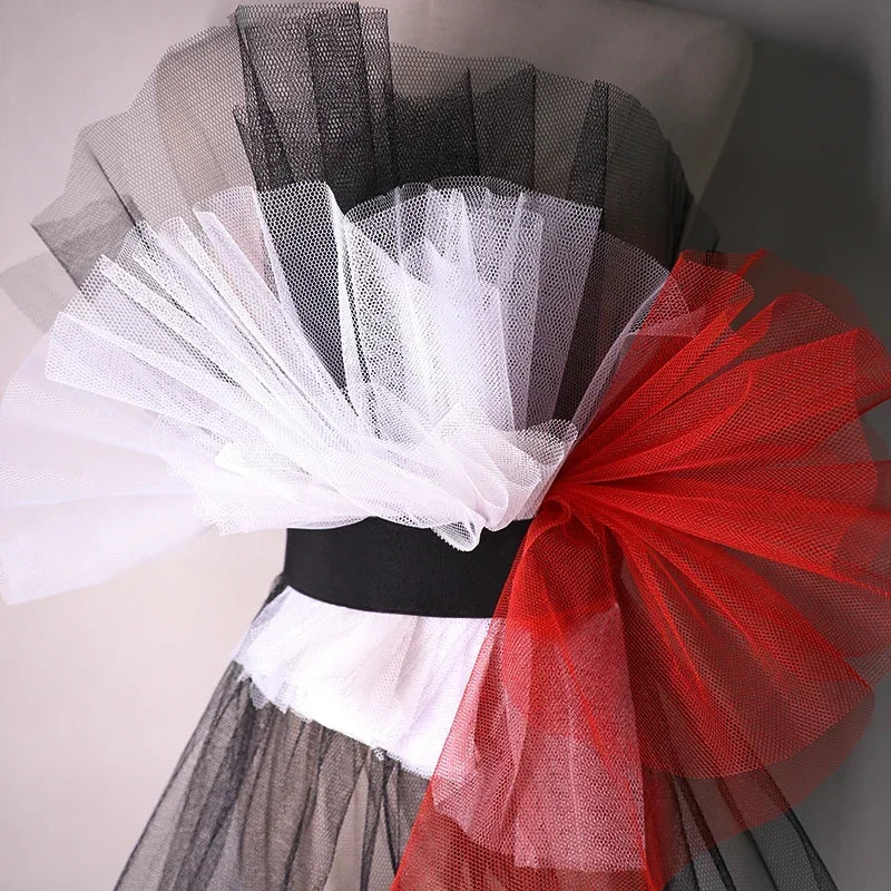 Black, white and red hexagonal support net gathered into upright folds