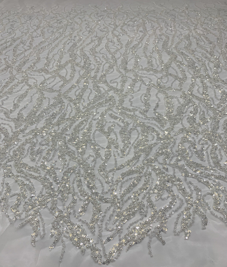 Detailed view of white mesh with fine silver sequin floral and curved embroidery