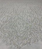 Detailed view of white mesh with fine silver sequin floral and curved embroidery