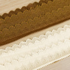 Close-up of brown and ivory stretch lace trim with plush textured scalloped borders