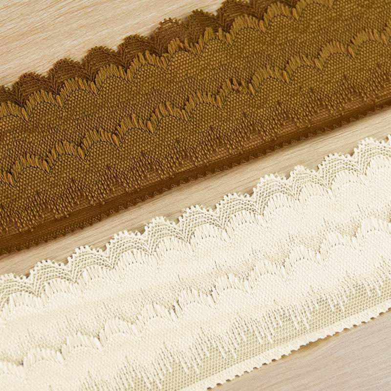 Close-up of brown and ivory stretch lace trim with plush textured scalloped borders