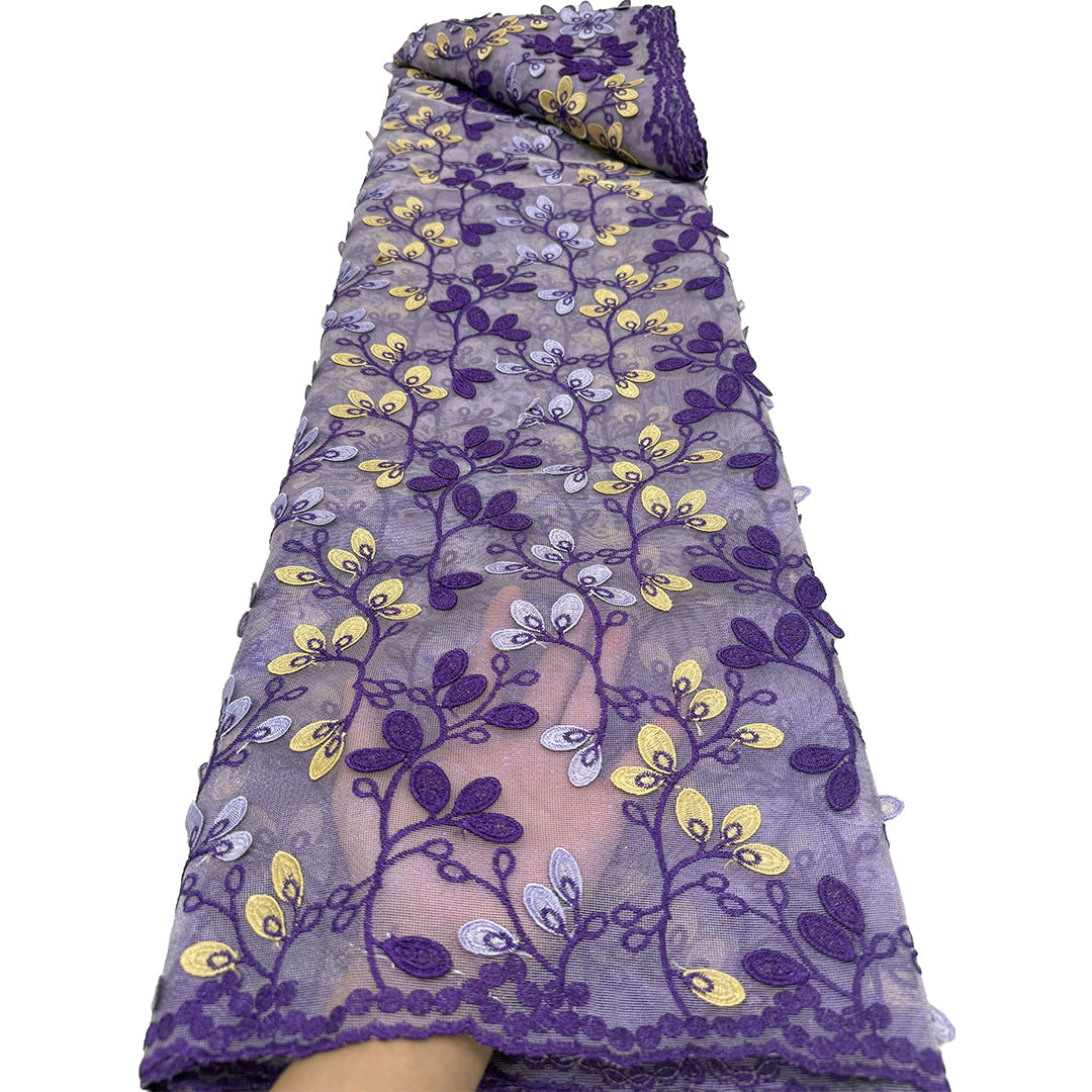 Folded roll of purple floral embroidered chiffon lace showing repeating vine pattern
