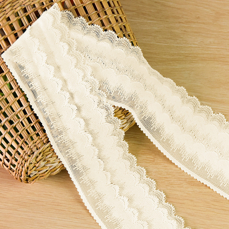 Ivory fuzzy lace edging laid in a loose loop to show width and soft texture