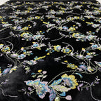 Close-up of sequined blue, cream and yellow floral embroidery on black velvet
