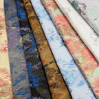 Folded rolls of floral and metallic decorative organza with different color patterns