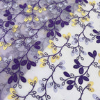 Close-up of purple and yellow embroidered vines and leaves across transparent chiffon