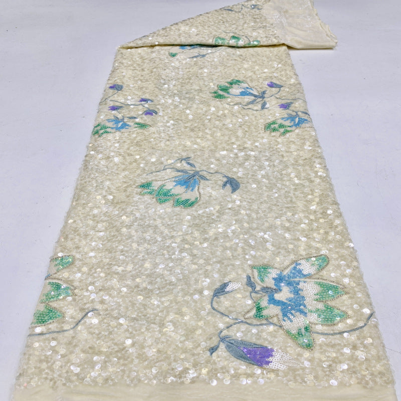 Beige velvet-base sequined fabric laid out with blue-green and lavender floral motifs