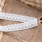 Two strips of narrow white geometric lace edging with repeating zigzag border