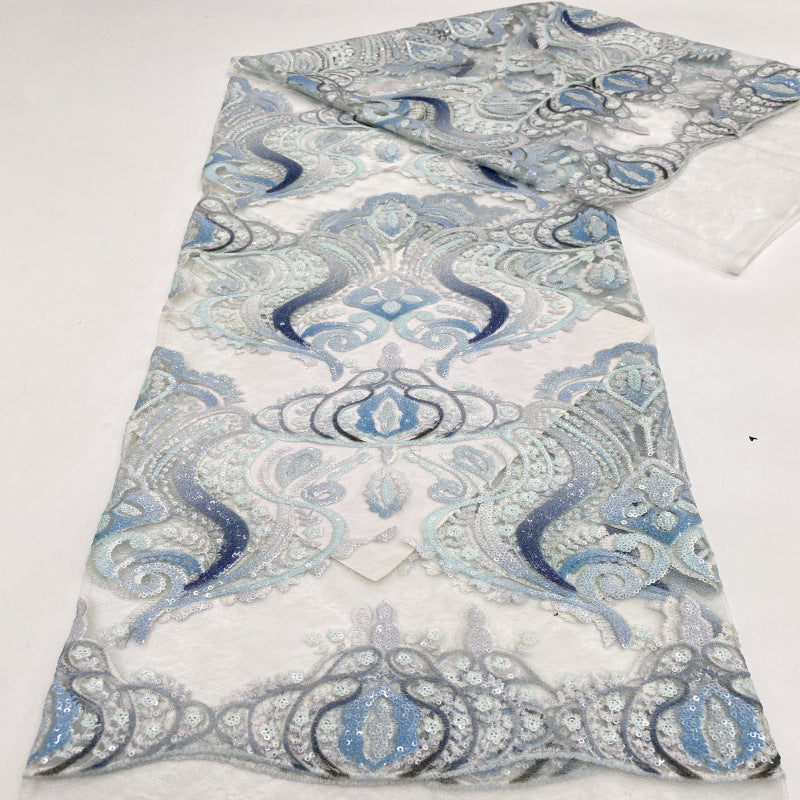 Blue and pastel pink printed guipure lace design shown across folded fabric