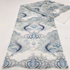 Blue and pastel pink printed guipure lace design shown across folded fabric
