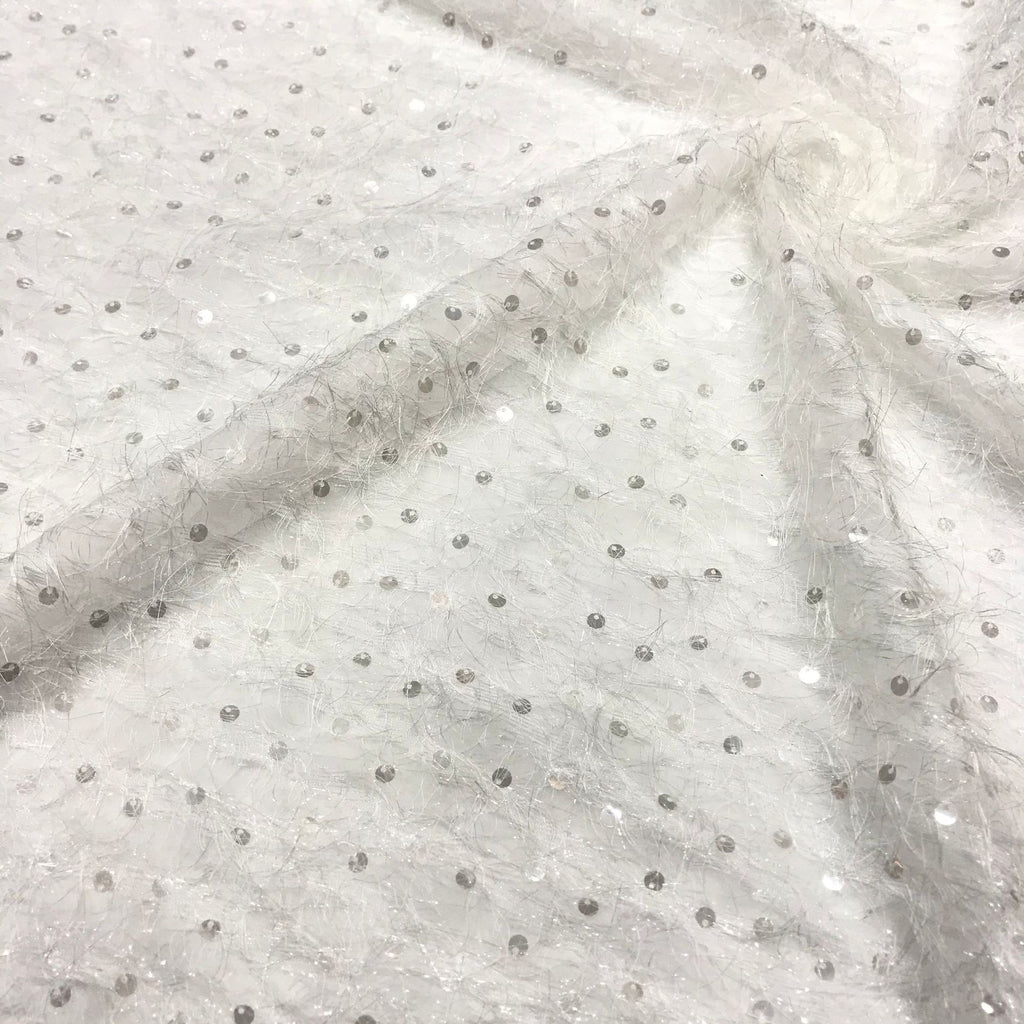 Close-up of pale sheer chiffon with fine silver crystal-look sequin embellishments