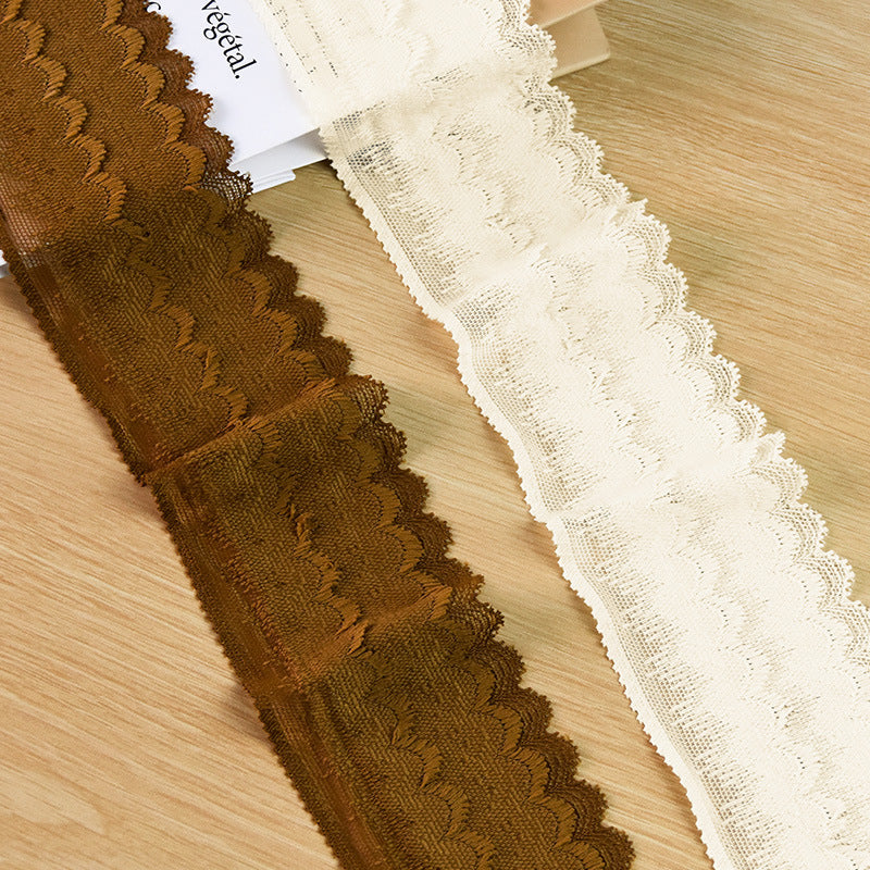 Brown and ivory fuzzy scalloped lace trim color samples on a wood surface