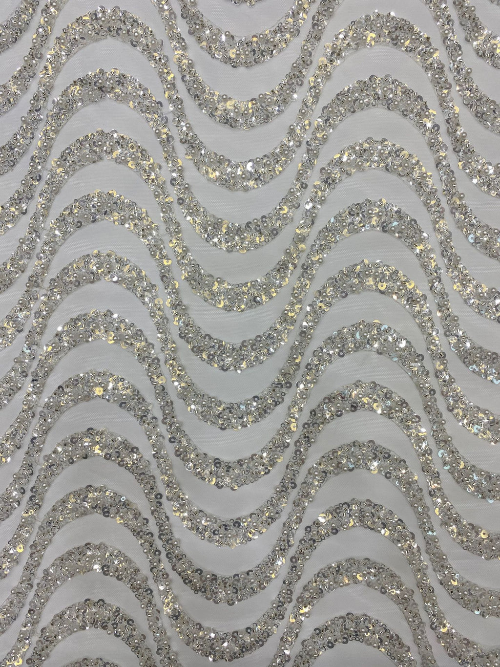 Detailed view of silver sequined wavy embroidery and translucent fabric ground