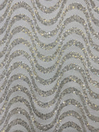Detailed view of silver sequined wavy embroidery and translucent fabric ground