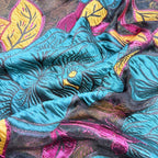 Bright turquoise floral metallic-thread organza displayed in colorful draped folds