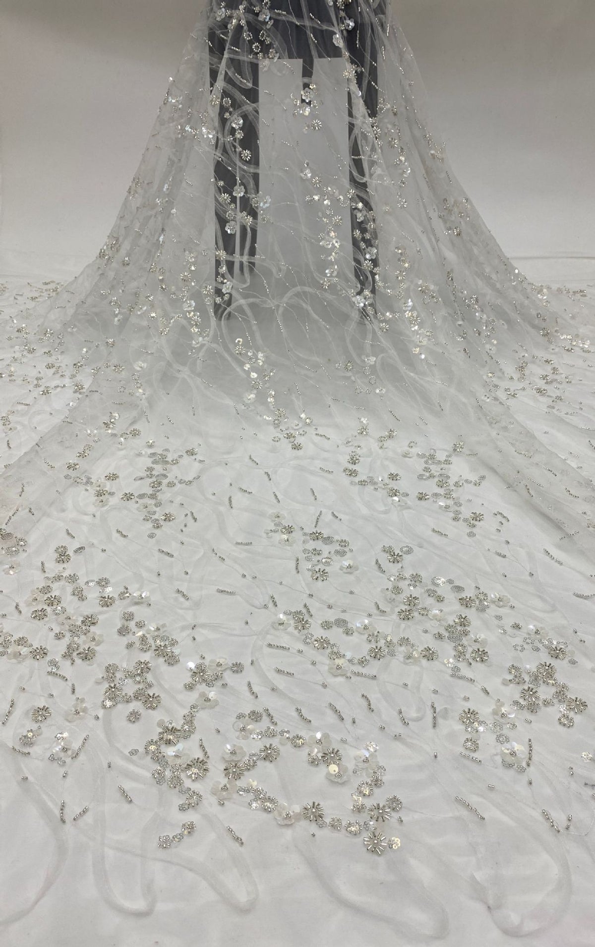 Draped ivory mesh fabric with silver beads and small sequined floral motifs