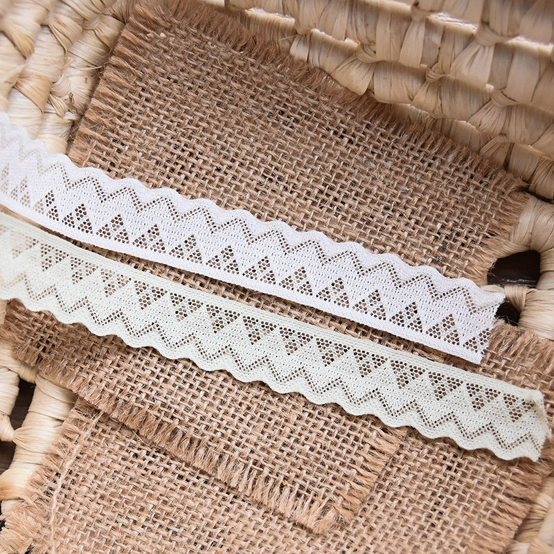 White geometric zigzag lace trim displayed against burlap with cut edges and narrow width