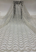 Silver sequin and bead embroidered bridal mesh hanging in a full drape with repeating wave motifs