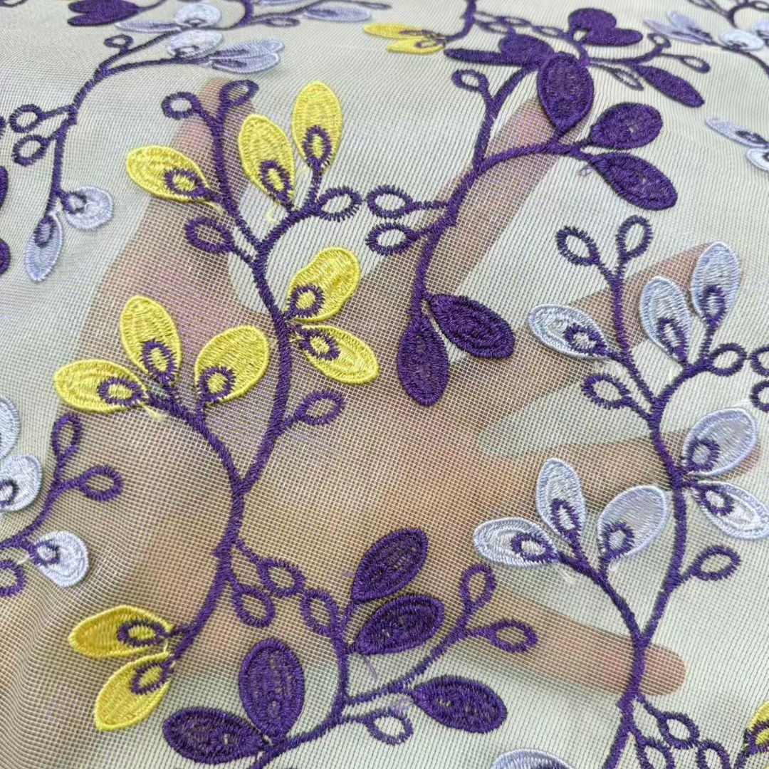 Sheer chiffon lace with purple and yellow floral vine embroidery on a pale base