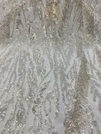 Detailed view of silver sequin embroidery across ivory translucent fabric
