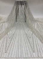 Ivory sheer bridal fabric draped to show long radiating silver bead and sequin lines