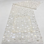 Close-up of white sheer fabric covered with silver and pearly round sequins