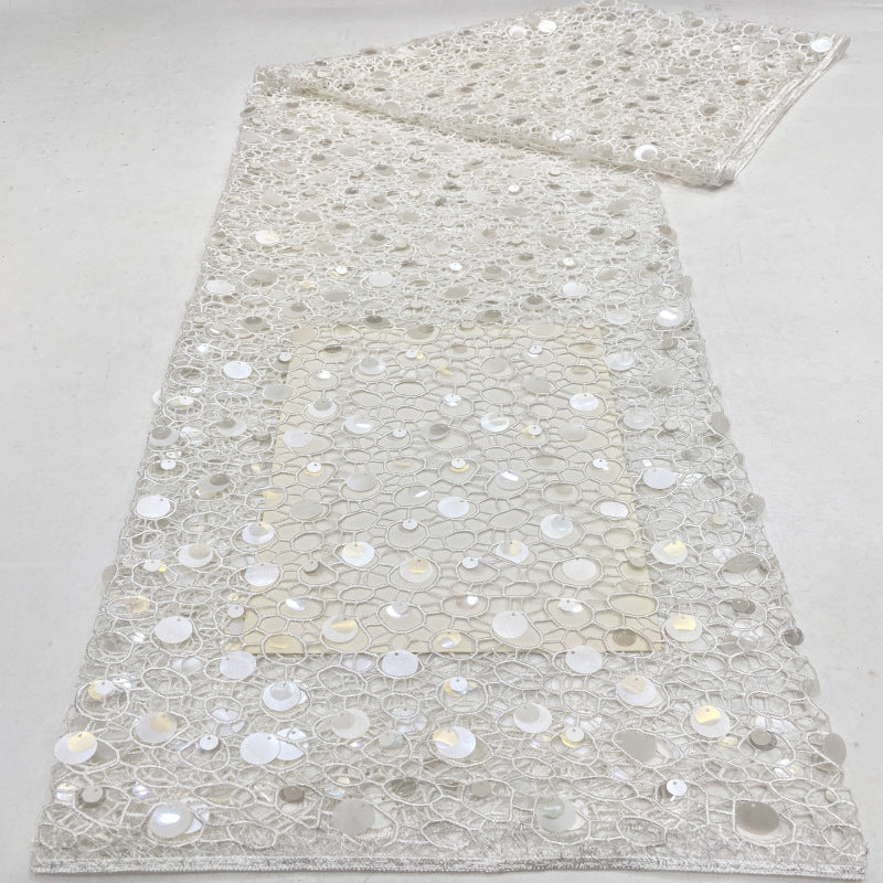 Close-up of white sheer fabric covered with silver and pearly round sequins