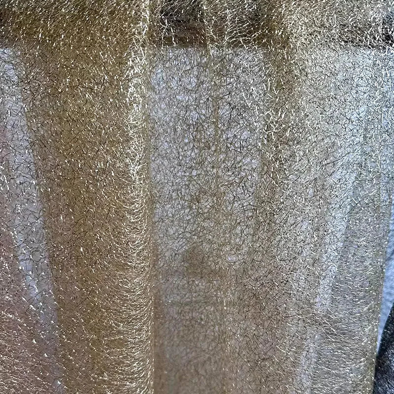 Tejido de malla de organza con hilo dorado de textura irregular: material de alta costura.