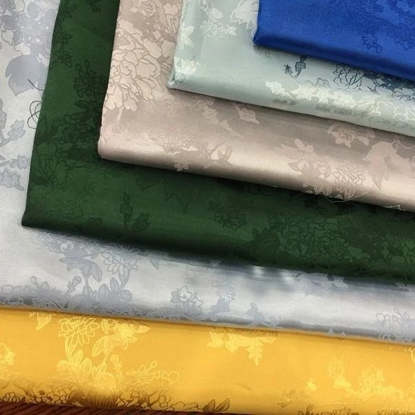 La tela de satén jacquard con flores de vid es suave y adecuada para vestidos de novia, vestidos formales y telas de ropa hechas a mano.