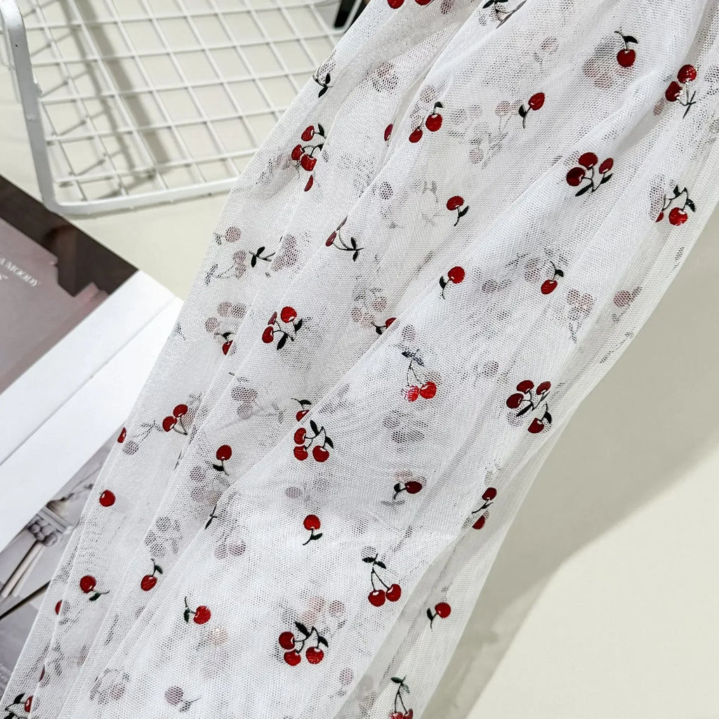 Tejido de malla elástica suave con hilo dorado y estampado de cerezas - Material transparente