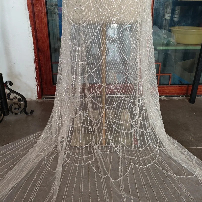 فستان زفاف رائع من اللؤلؤ الأبيض من قماش الدانتيل المجوف من اللؤلؤ المطرز بالخرز والأظافر وتصميم الملابس وإكسسوارات الدانتيل