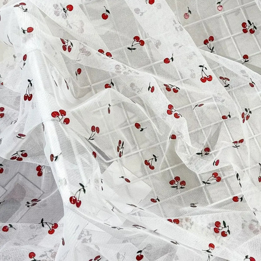 Tejido de malla elástica suave con hilo dorado y estampado de cerezas - Material transparente