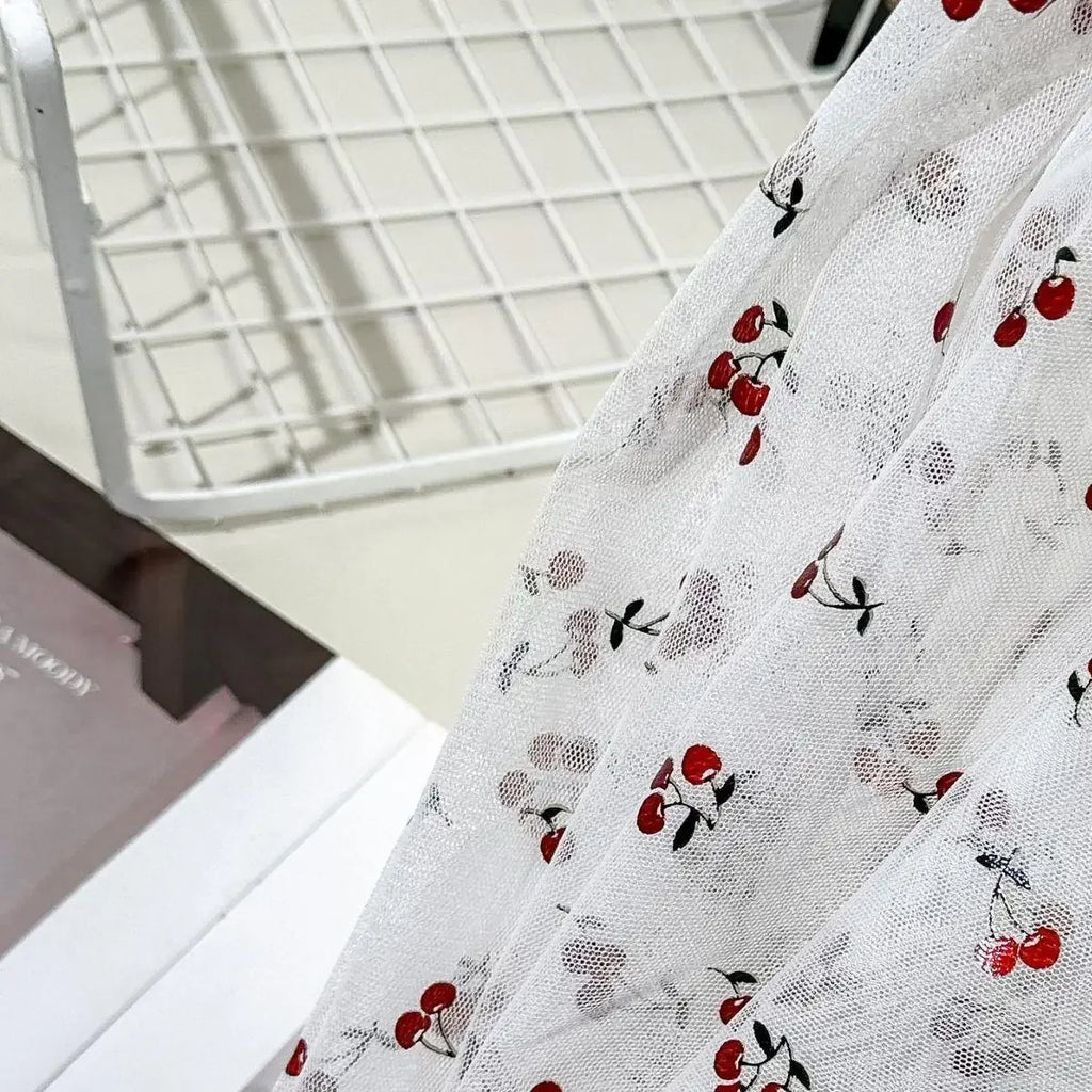 Tejido de malla elástica suave con hilo dorado y estampado de cerezas - Material transparente