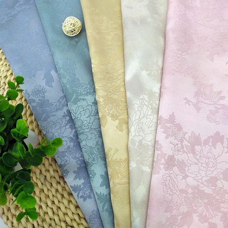 La tela de satén jacquard con flores de vid es suave y adecuada para vestidos de novia, vestidos formales y telas de ropa hechas a mano.