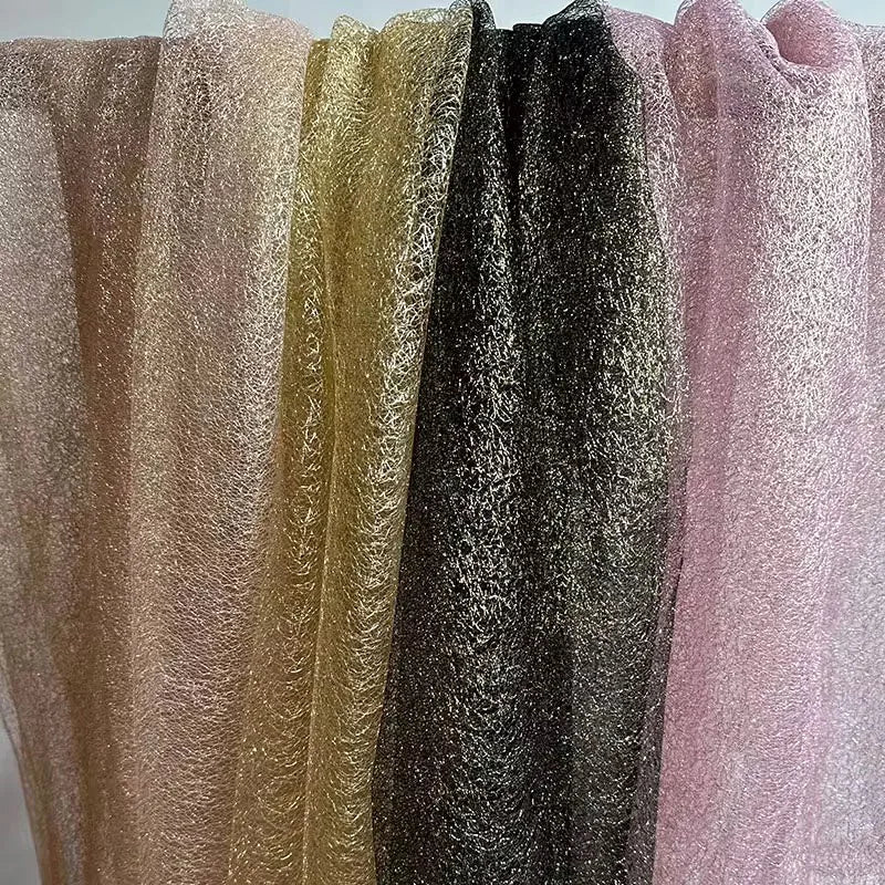 Tejido de malla de organza con hilo dorado de textura irregular: material de alta costura.