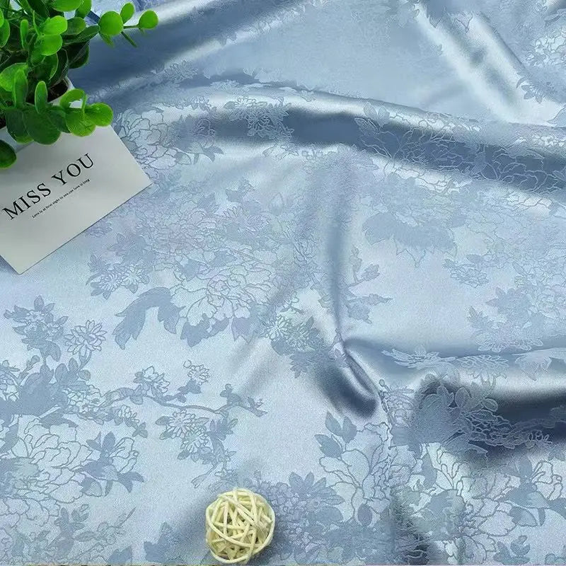 La tela de satén jacquard con flores de vid es suave y adecuada para vestidos de novia, vestidos formales y telas de ropa hechas a mano.