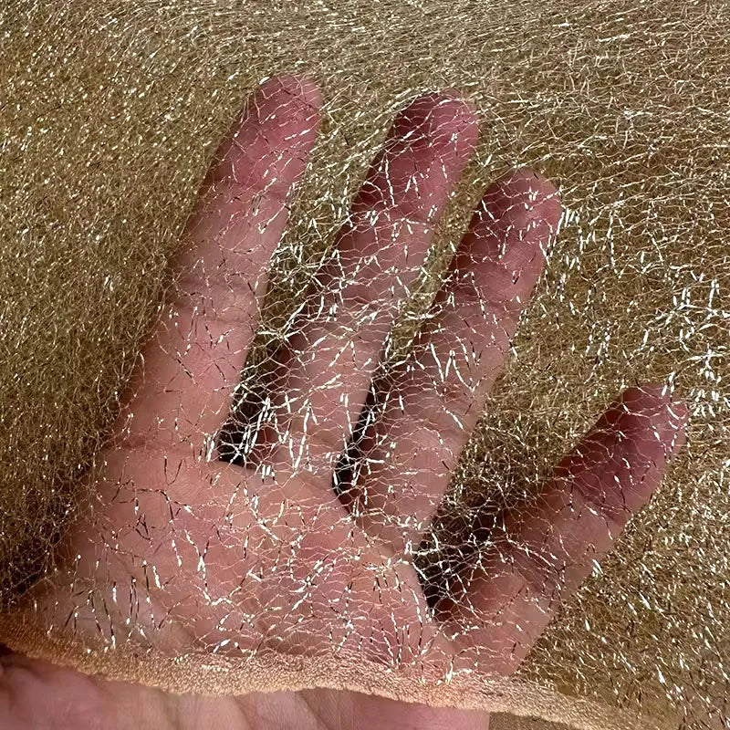 Tejido de malla de organza con hilo dorado de textura irregular: material de alta costura.