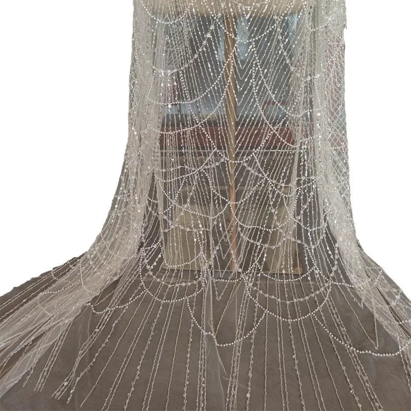 فستان زفاف رائع من اللؤلؤ الأبيض من قماش الدانتيل المجوف من اللؤلؤ المطرز بالخرز والأظافر وتصميم الملابس وإكسسوارات الدانتيل