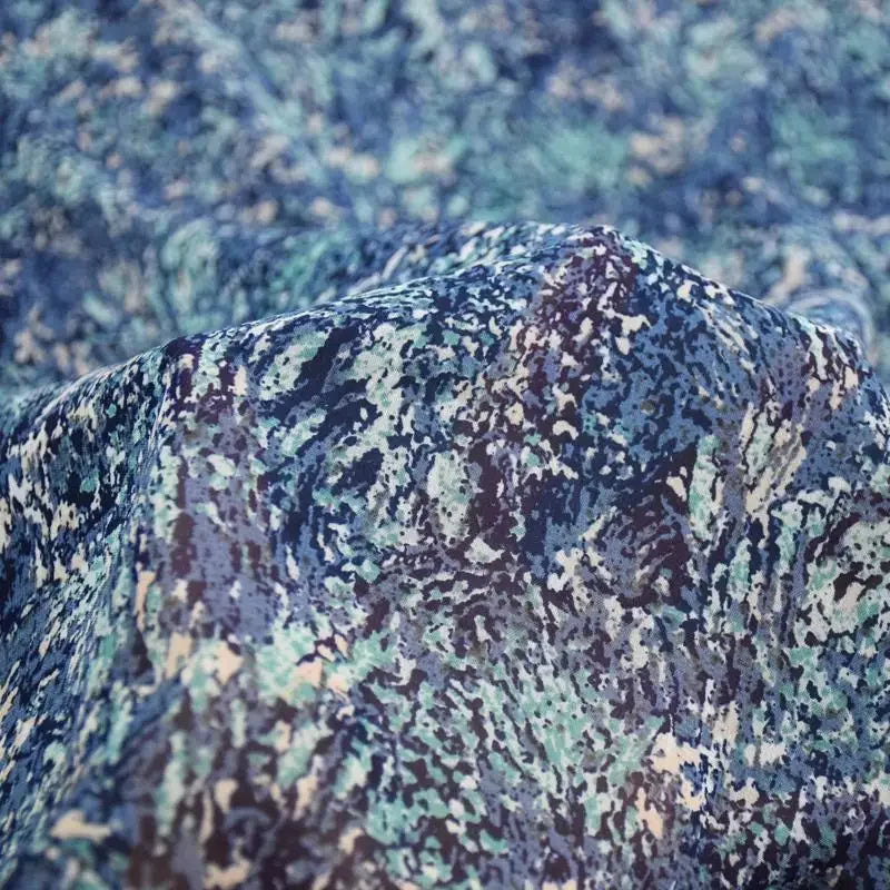 قميص فستان أنيق مصنوع يدويًا من قماش شيفون مطبوع عليه زهور تجريدية باللون الأزرق والأخضر ولؤلؤي وشفاف قليلاً بنمط صغير