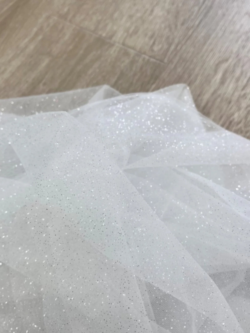 White fine sparkling silver powder with a hard and shiny transparent mesh background for wedding dress fabric decoration